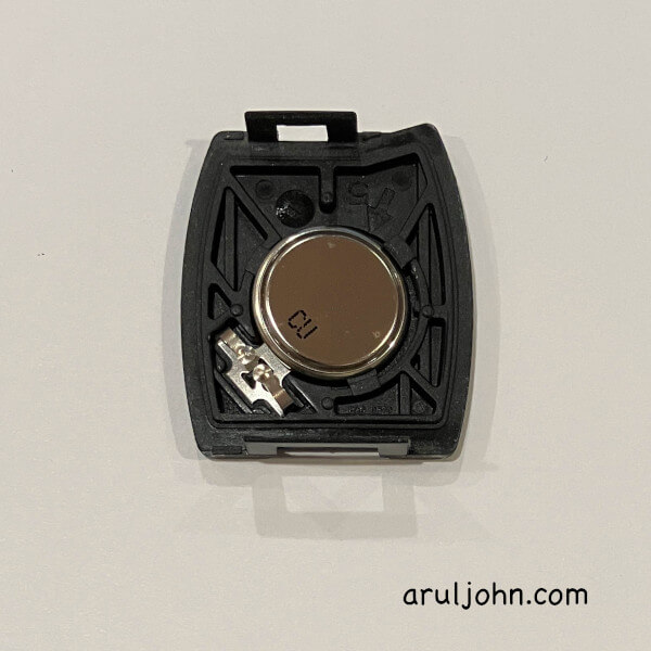 Remove the old CR 1616 key fob battery from the back of the compartment